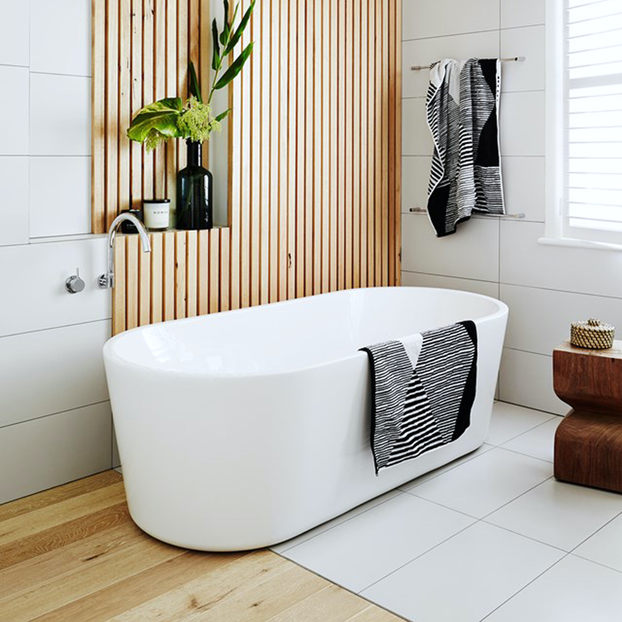 Cuarto de baño contemporáneo con una moderna bañera independiente, paneles de madera en la pared y transición de madera a azulejos.