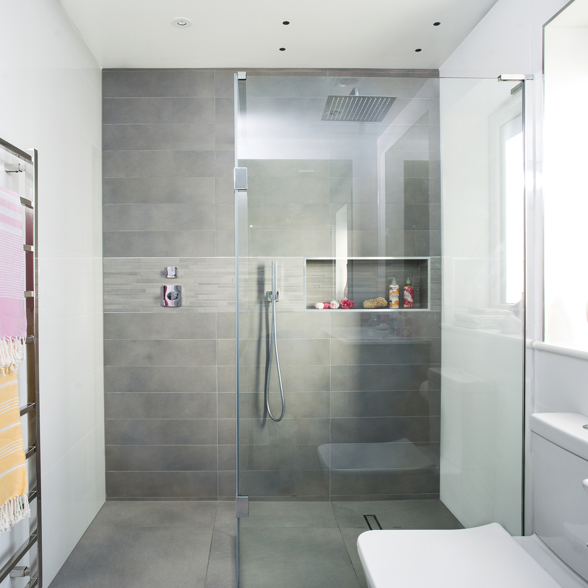 iluminacion en duchas: cuarto de baño moderno con ducha gris y mampara de cristal sin marco