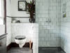 black and white bathroom with white wall tiles and black mosaic flooring