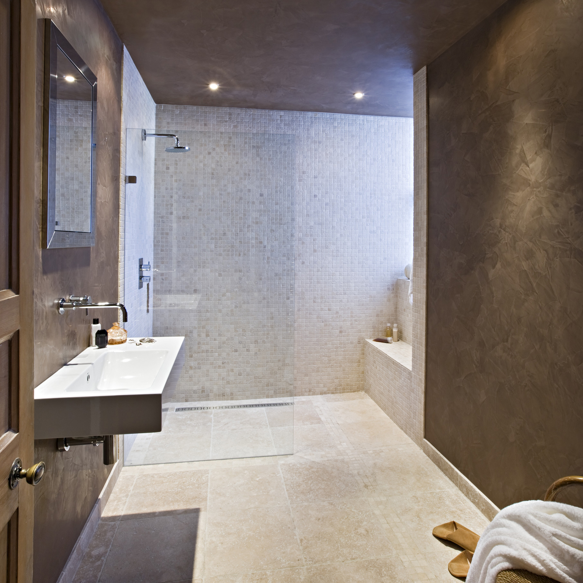 iluminacion ducha: ducha de baño con azulejos de travertino caídos, tonos neutros